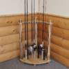 Corner wooden fishing pole holder with rods and reels and padded baseplate guides.
