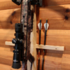 Wall-mounted crossbow rack with built-in arrow storage for secure wall display.